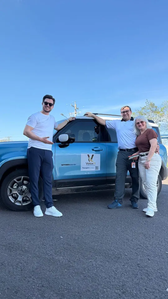 Equipe da Velox11 ao lado de um carro adesivado com a marca Velox11